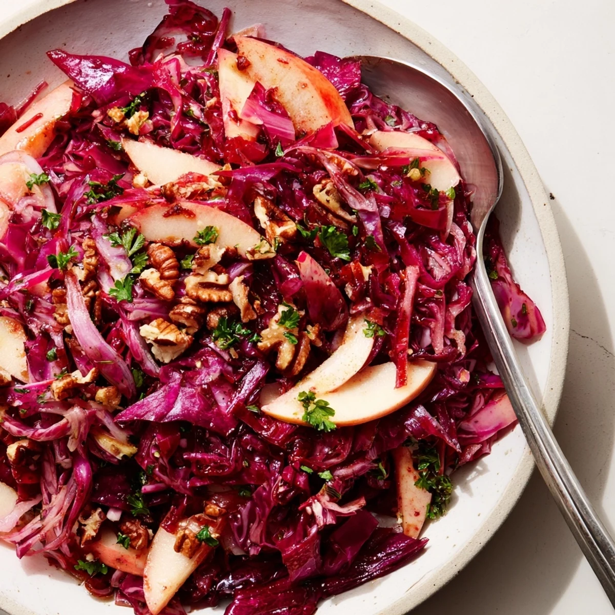 Süß-säuerlicher Warm Red Cabbage Salad, serviert mit knackigen Nüssen als Garnitur.  