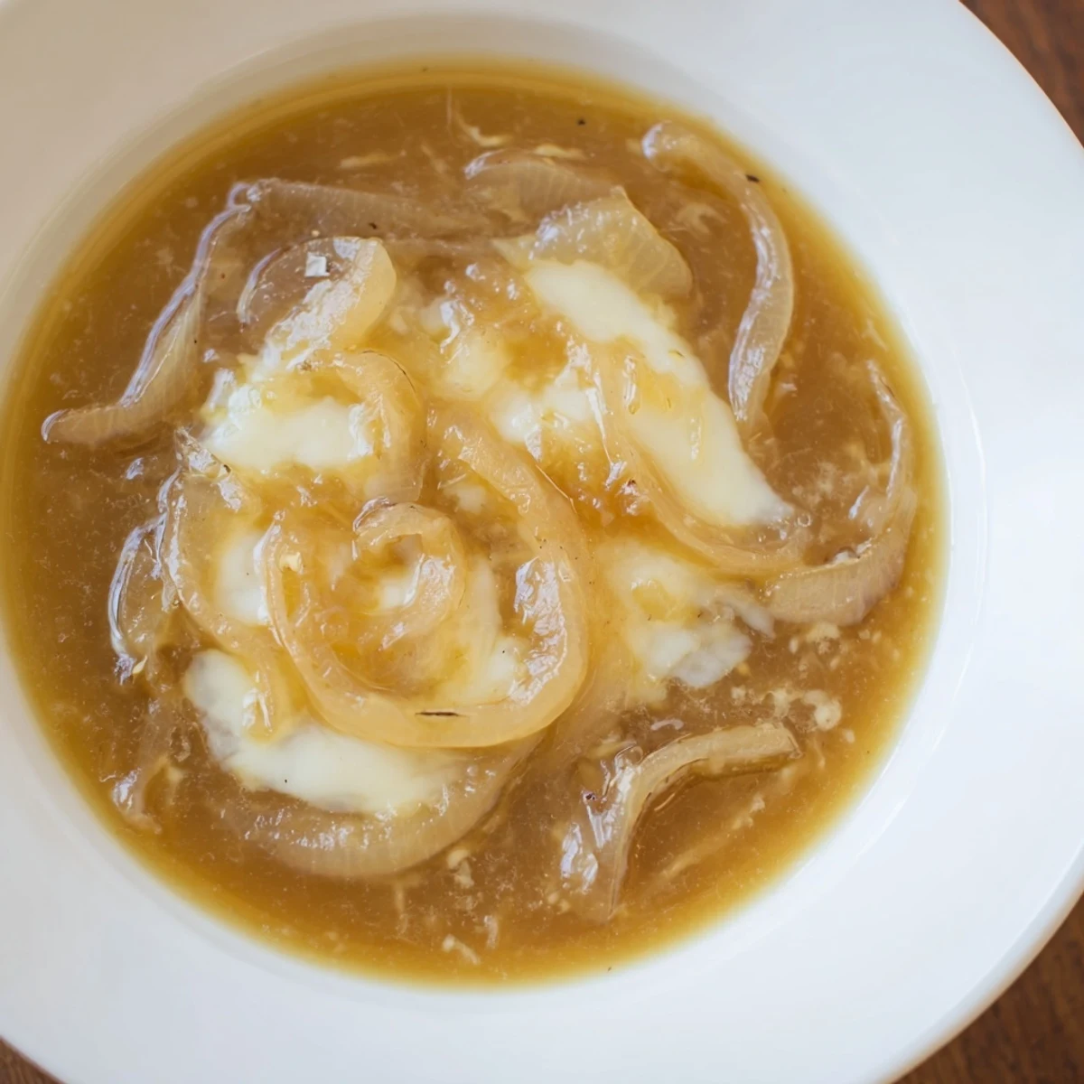 Golden, bubbling German Cheese and Onion Beer Soup, a delicious comfort food with melted cheese.