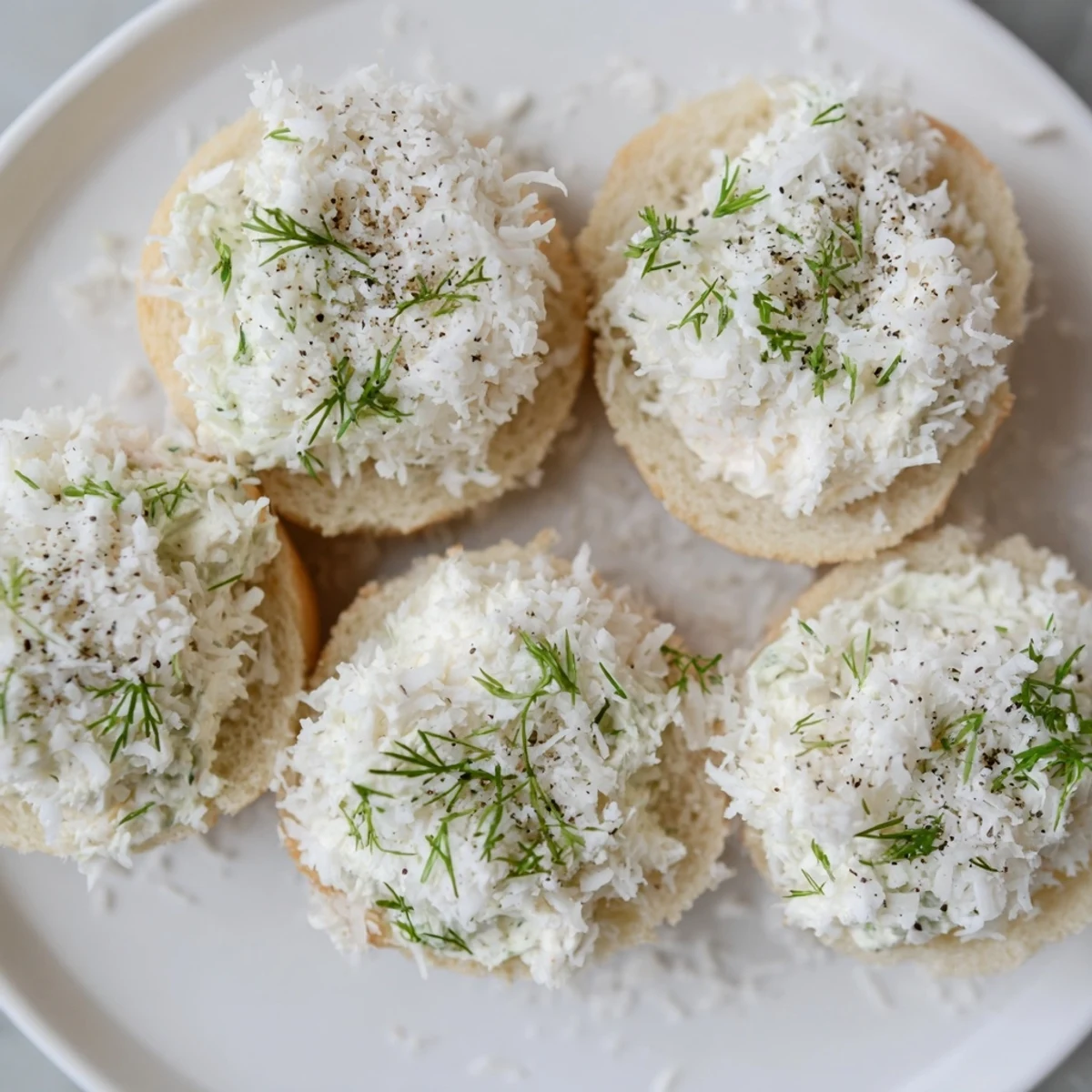 Fluffy, coconut-covered Snowball Tea Sandwich Bites, a delightful finger food perfect for a winter party.