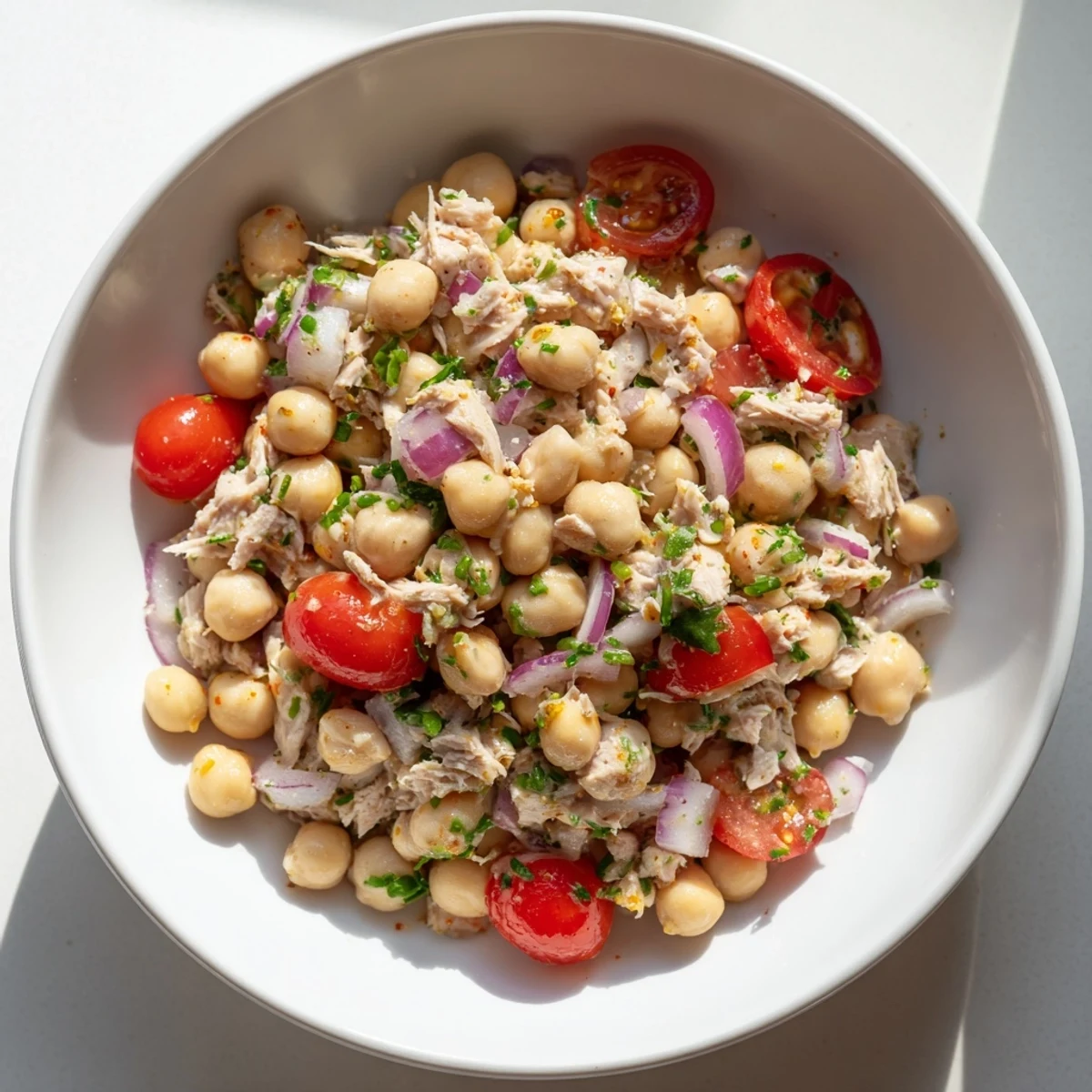 Creamy Dense Chickpea and Tuna Salad, ready to eat, served with fresh parsley garnish.