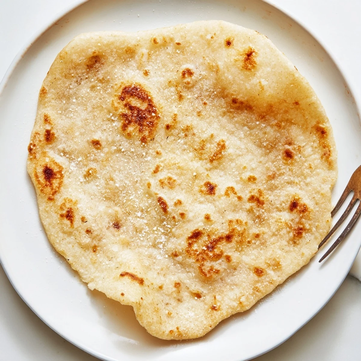 A stack of fluffy cottage cheese flatbreads, slightly browned and ready for your favorite wraps.