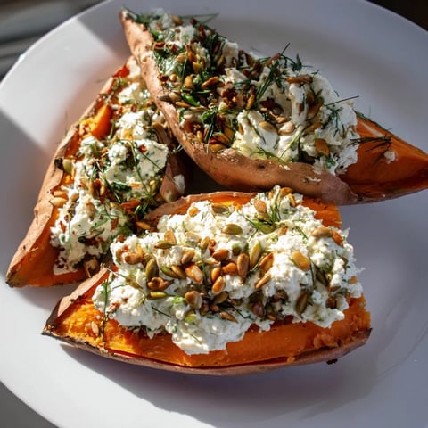 Oven-baked sweet potato stuffed with creamy cottage cheese, herbs, ready to serve, a vegetarian delight.
