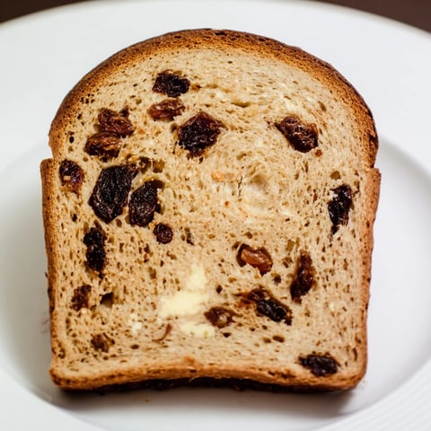 Golden-brown Old-Fashioned German Raisin Bread, sliced, ready for butter—a warm, comforting treat.