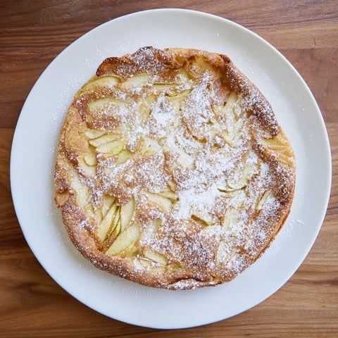 Fluffy German apple pancakes, golden brown and drizzled with syrup, make a comforting breakfast.