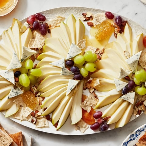 A visually appealing Art Deco Arch Cheese Platter with layered cheese arches, grapes, and nuts.