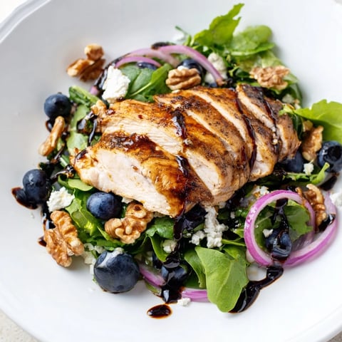 Saftige Blaubeer-Ziegenkäse-Hühnchen-Salat, serviert mit cremigen Ziegenkäsekrümeln und knusprigen Walnüssen.