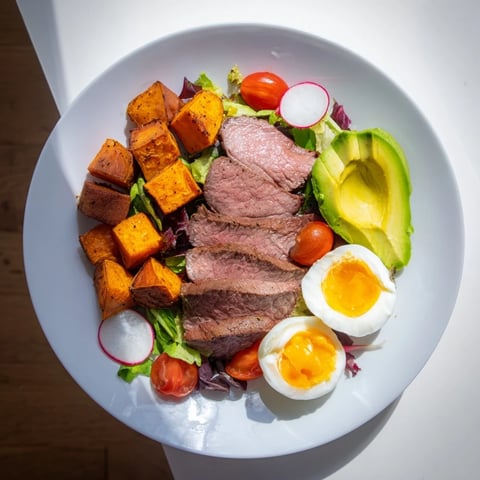 A juicy High-Protein Beef Avocado Bowl showcases sliced steak, creamy avocado, and a perfect egg.
