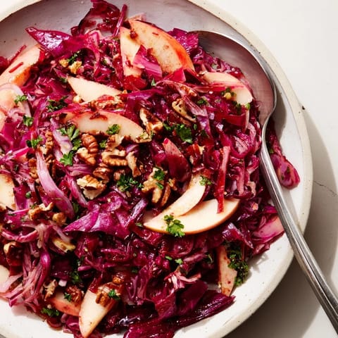 Süß-säuerlicher Warm Red Cabbage Salad, serviert mit knackigen Nüssen als Garnitur.  