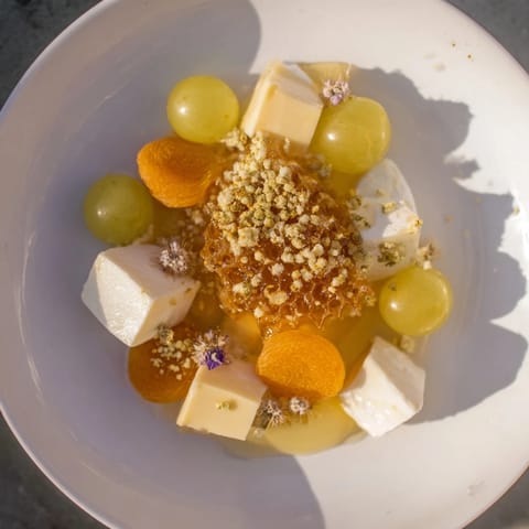 Das wunderschöne Busy Bee Honeycomb Snack Plate: Nahaufnahme mit Käse, Obst, und knackigen Elementen, sofort servierbereit.