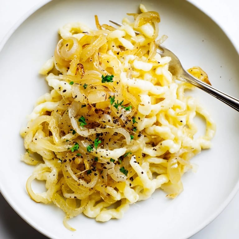 Sanfte Spaetzle mit aromatischen caramelisierten Zwiebeln, perfekt als Beilage oder Hauptgericht.  