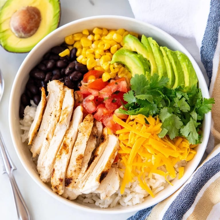 Leckerer Tex-Mex Burrito Bowl mit scharfem Hähnchen, Reis, Bohnen und Avocado.