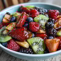 Bunter Frühlingsfrucht-Teller mit Honig-Joghurt-Dip – frische, saisonale Früchte kunstvoll arrangiert mit cremiger Dip-Sauce.  