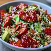 Eine leuchtende Erdbeer-Avocado-Quinoa-Salat mit frischen Beeren, cremiger Avocado und zitronigem Dressing.